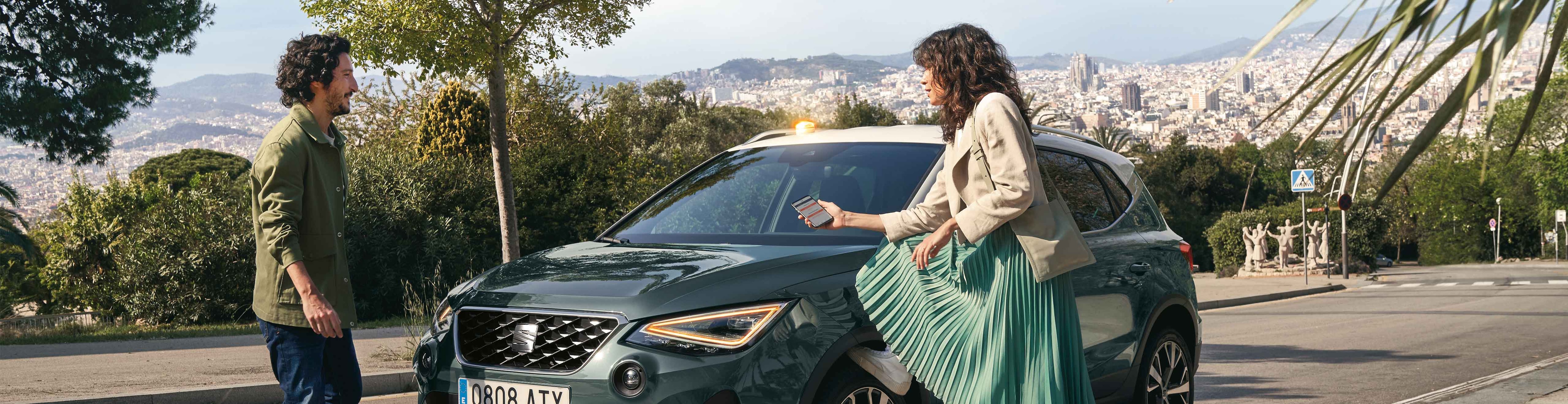 Couple talking in front of the SEAT Arona dark camouflage